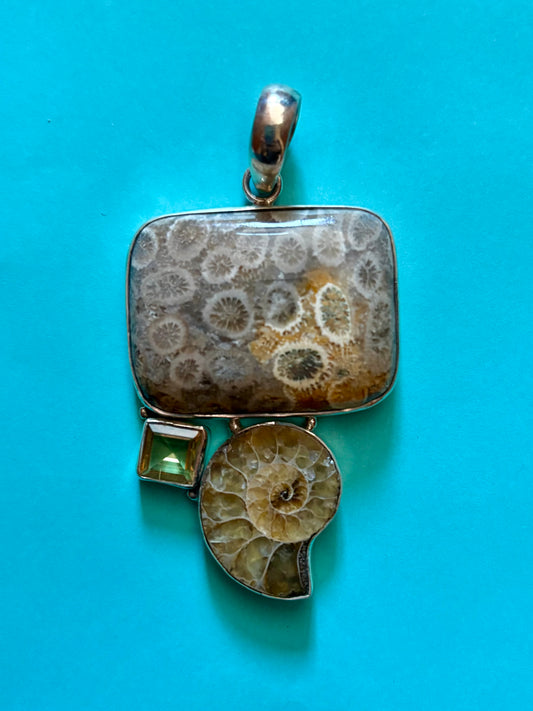 Jewelry pendant with fossil design on a blue background