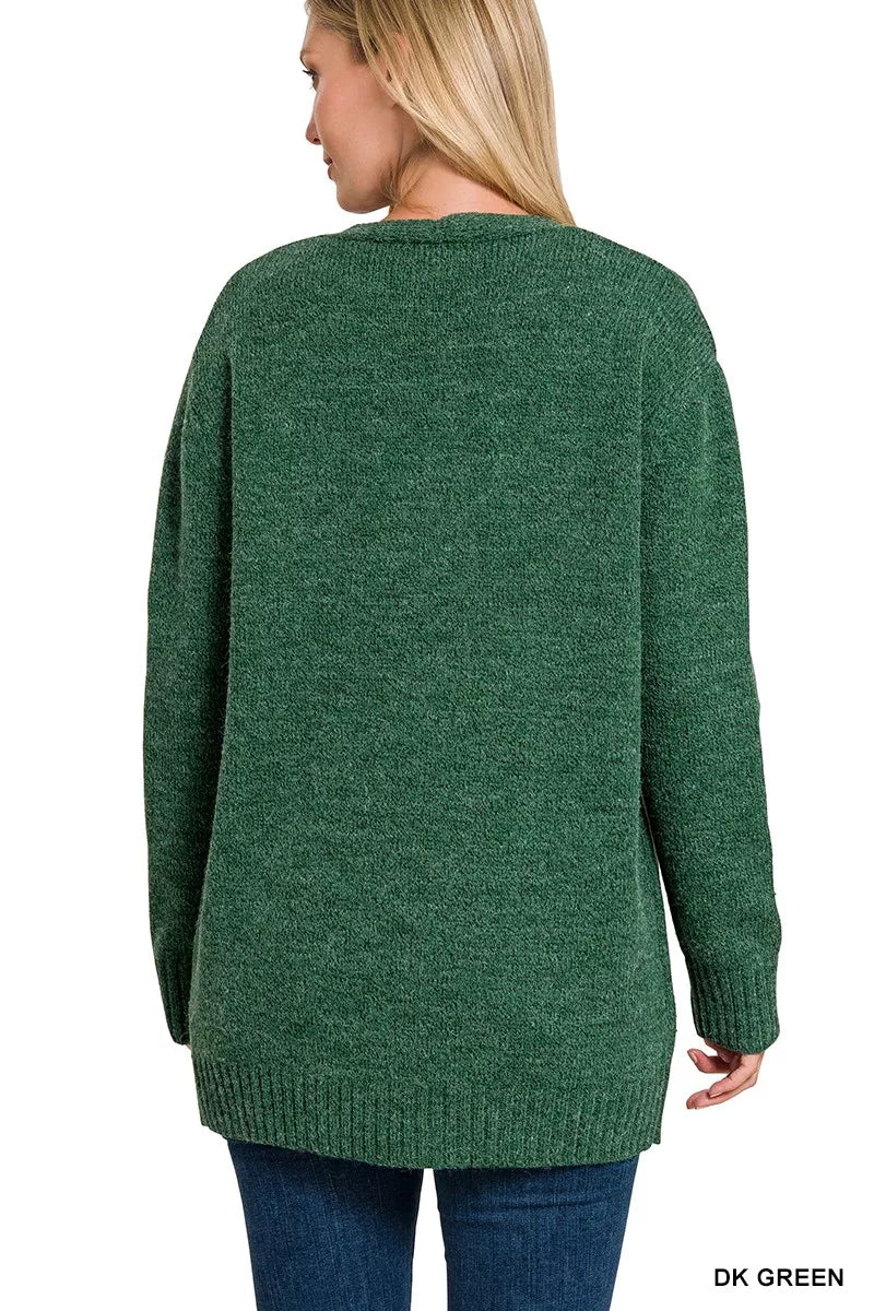 Open-front knit cardigan with front pockets, ribbed trim, long sleeves, and a relaxed slightly stretchy fit styled with jeans.