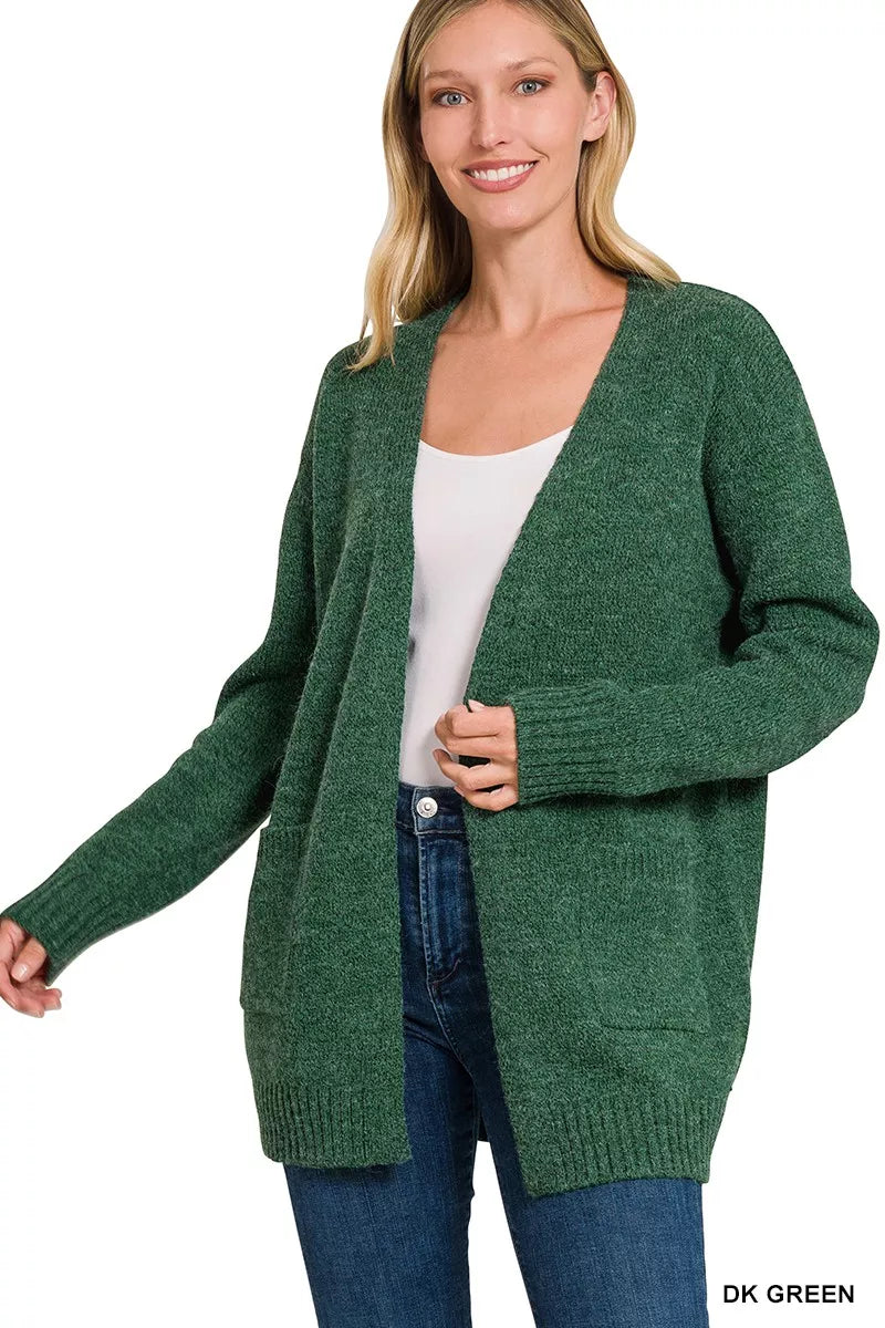 Open-front knit cardigan with front pockets, ribbed trim, long sleeves, and a relaxed slightly stretchy fit styled with jeans.