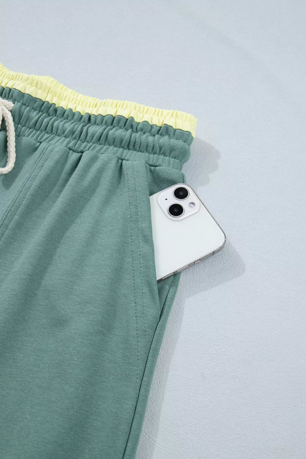 Teal wide-leg sweatpants with drawstring waist, front pockets, and colorful floral appliqué details.