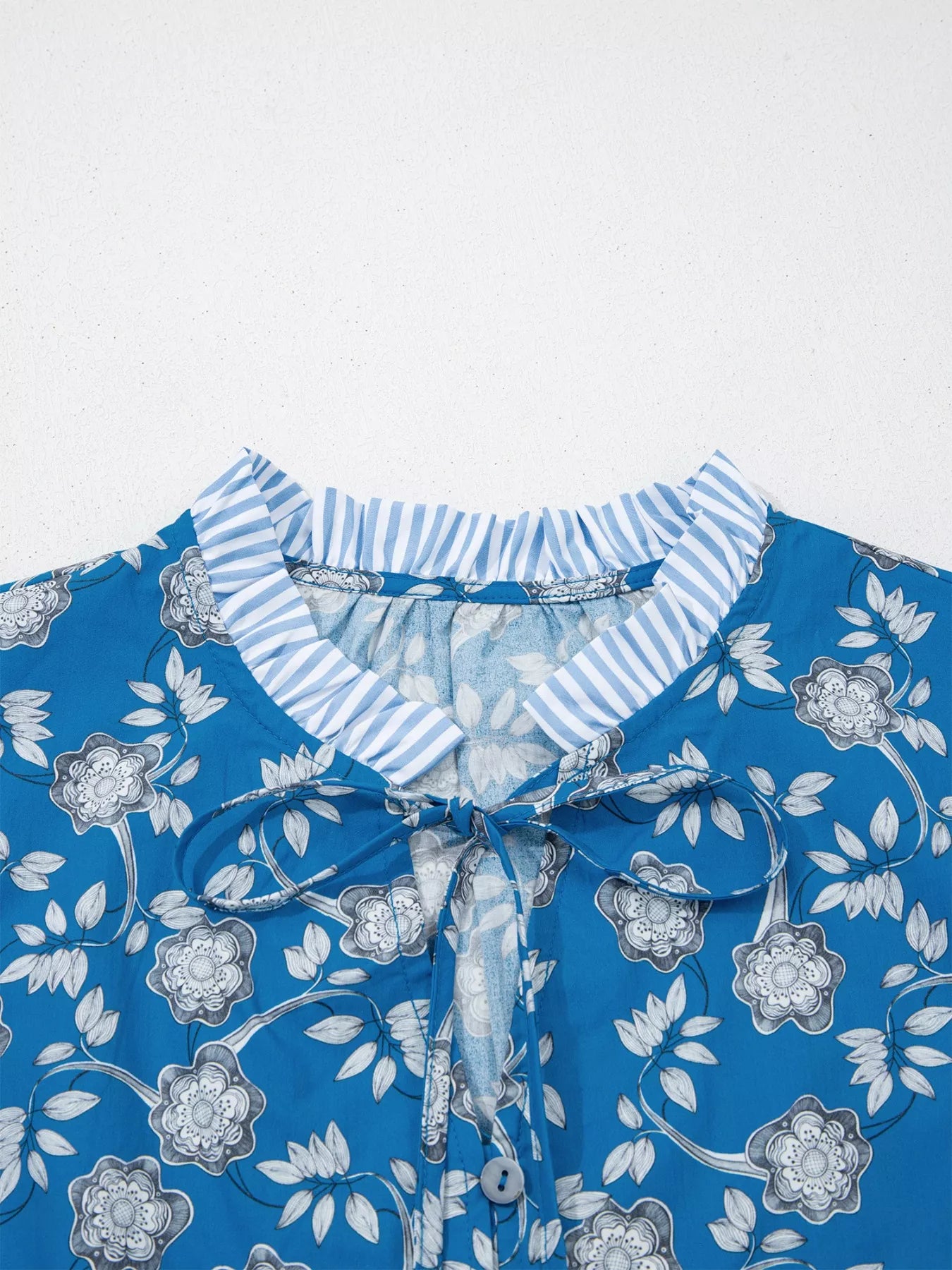Blue floral cotton blouse with striped ruffle trim and tie neckline