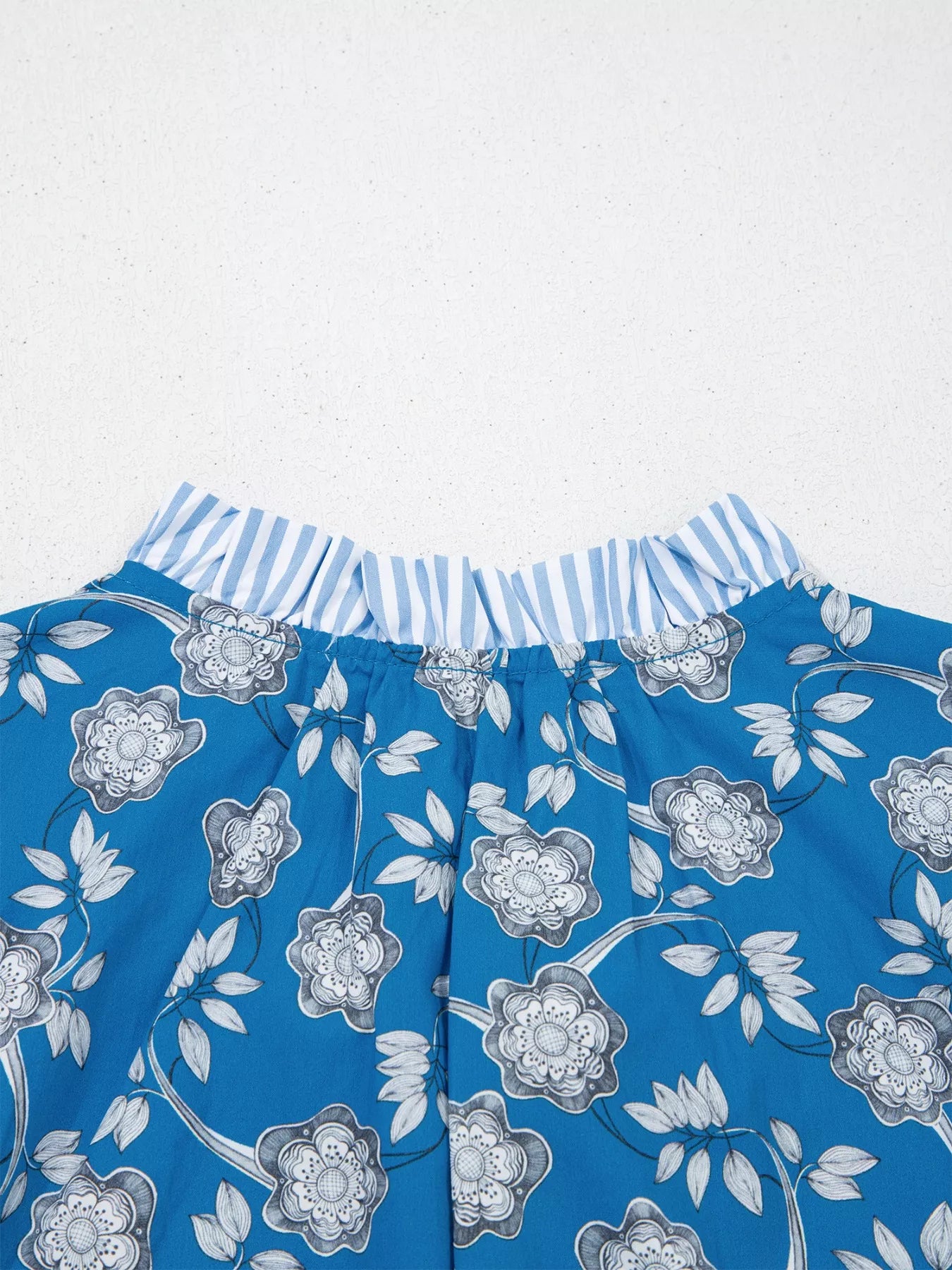 Blue floral cotton blouse with striped ruffle trim and tie neckline