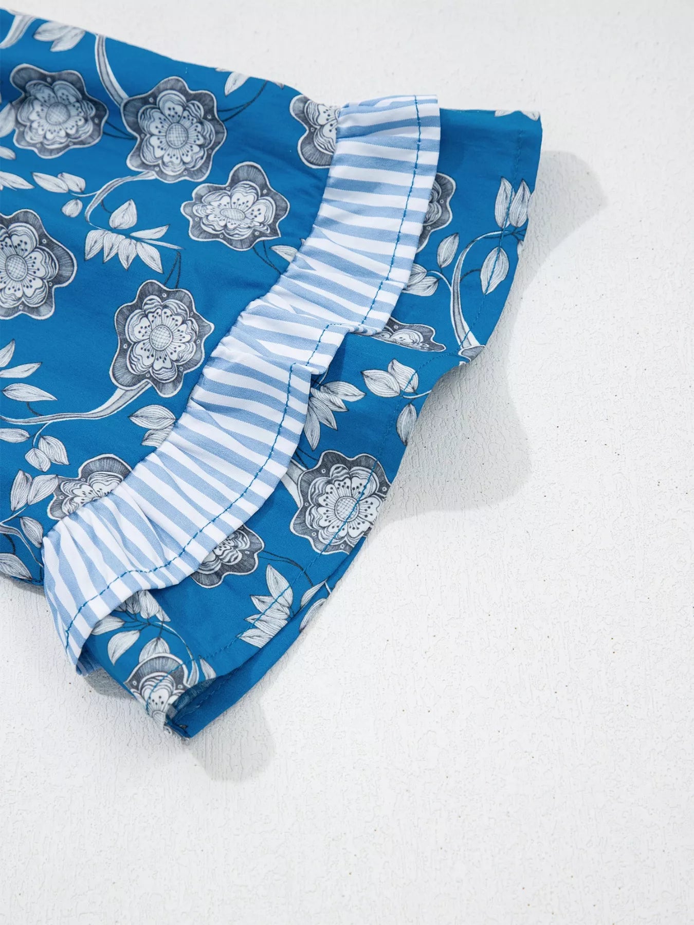 Blue floral cotton blouse with striped ruffle trim and tie neckline