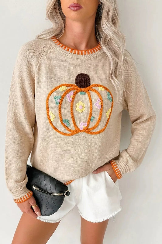 Cream knit sweater with embroidered pumpkin design, tiny floral accents, orange trim, seam details, and slightly stretchy fabric.
