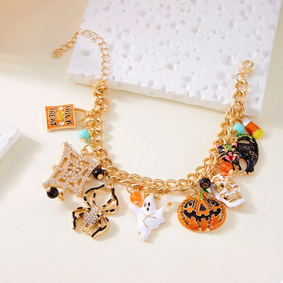 Haunting Charms Halloween Bracelet – 18K gold-plated bracelet with spiderweb, gem, and Halloween-themed charms.