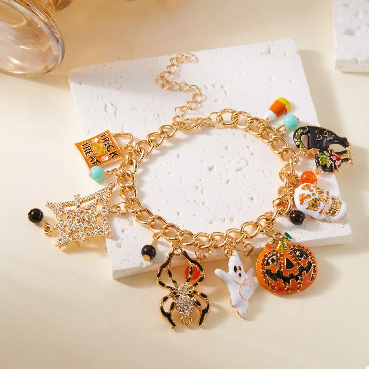 Haunting Charms Halloween Bracelet – 18K gold-plated bracelet with spiderweb, gem, and Halloween-themed charms.