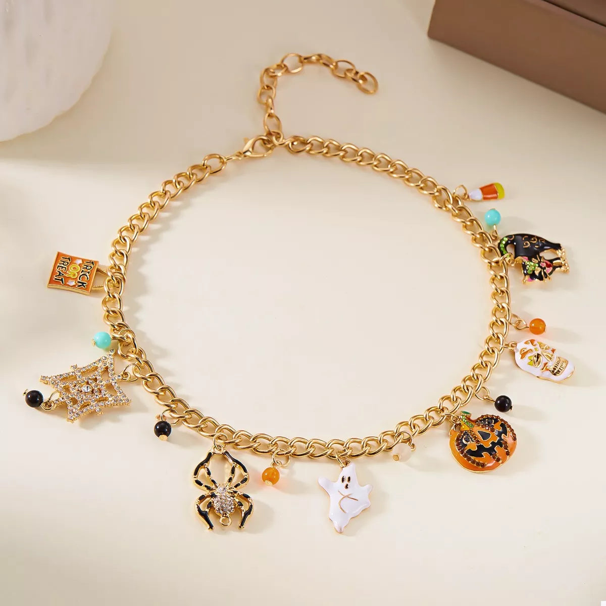 Haunting Charms Halloween Bracelet – 18K gold-plated bracelet with spiderweb, gem, and Halloween-themed charms.