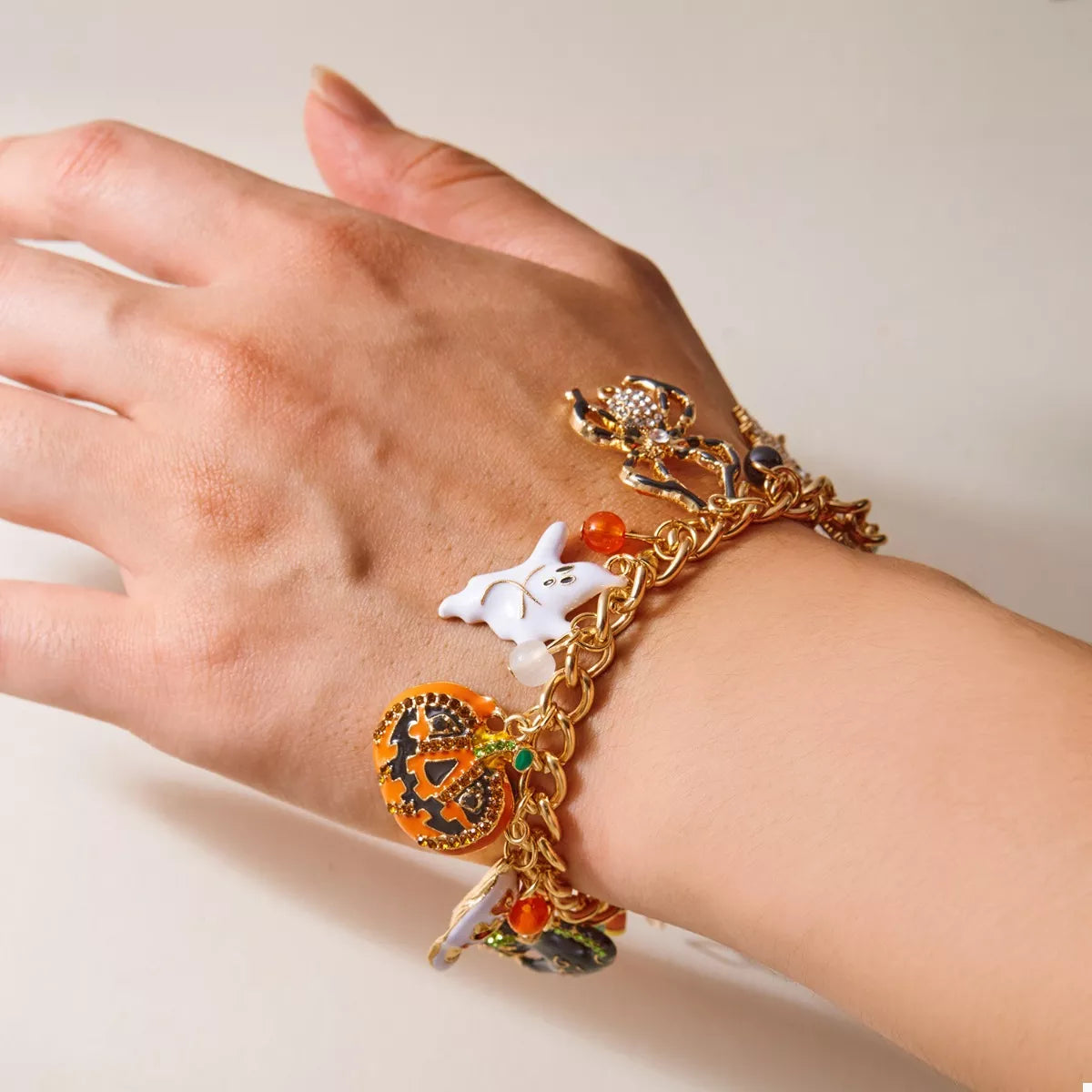 Haunting Charms Halloween Bracelet – 18K gold-plated bracelet with spiderweb, gem, and Halloween-themed charms.