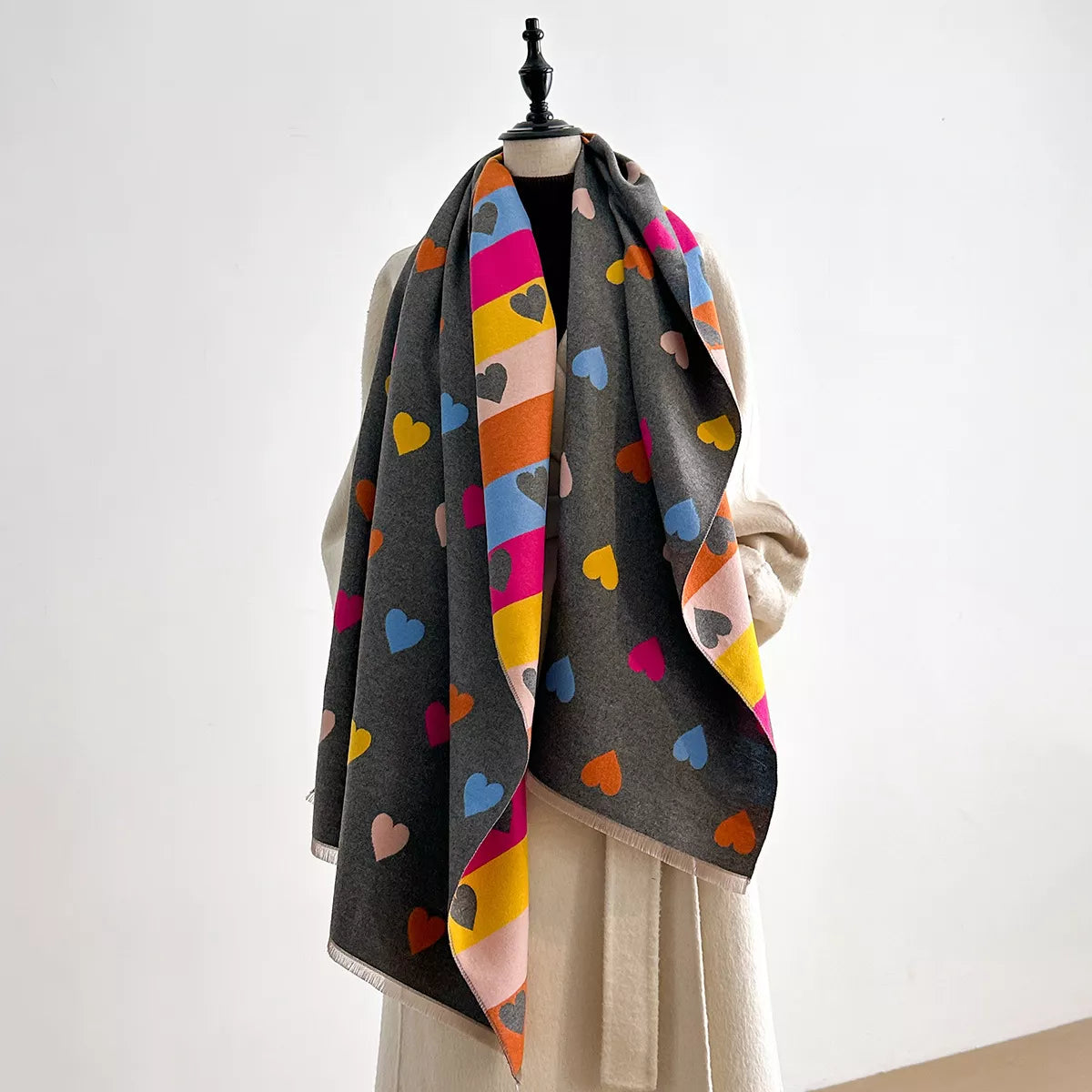 Soft wrap scarf with heart pattern and striped design draped on a dress form