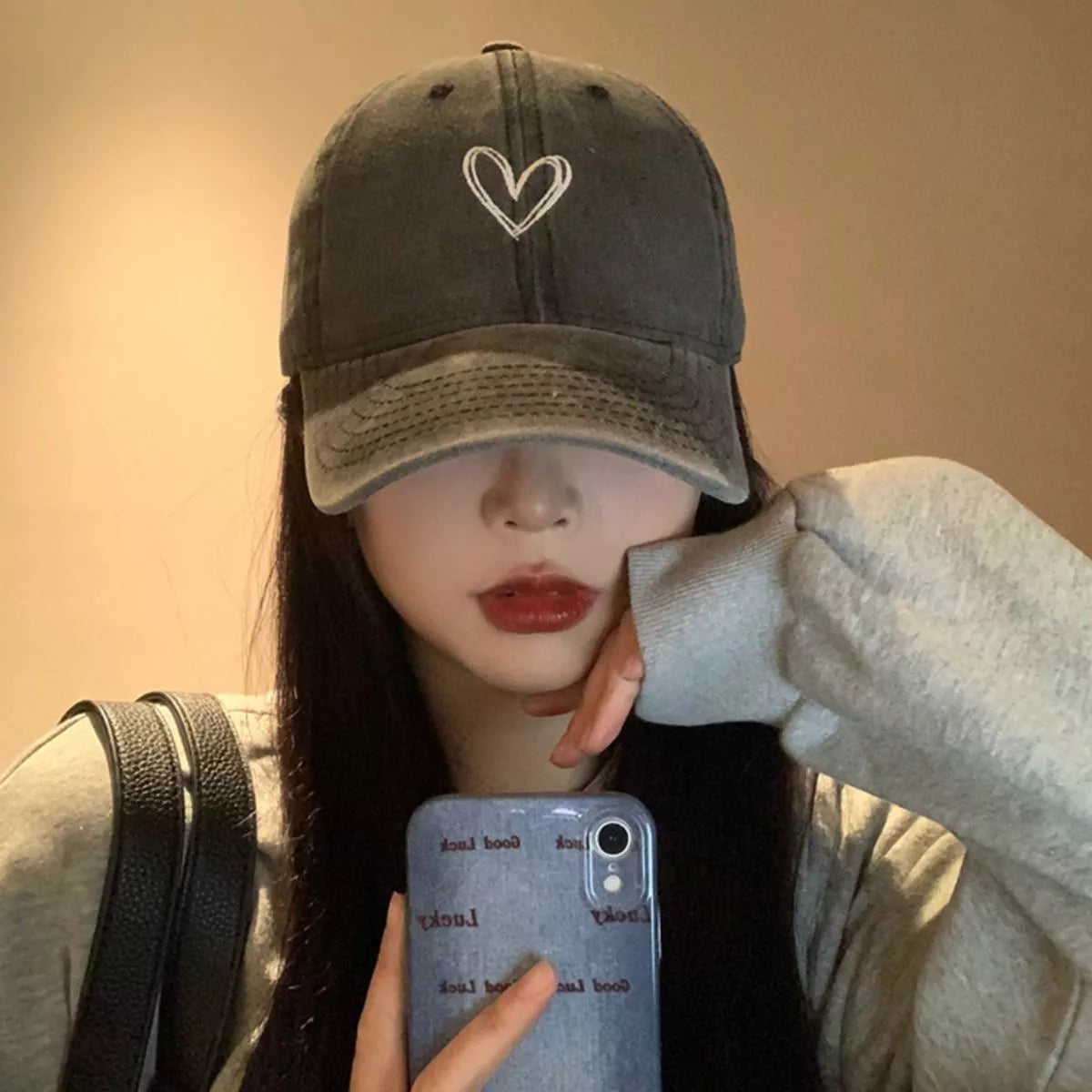 Vintage-washed cotton baseball cap with embroidered heart detail, curved brim, and adjustable back.
