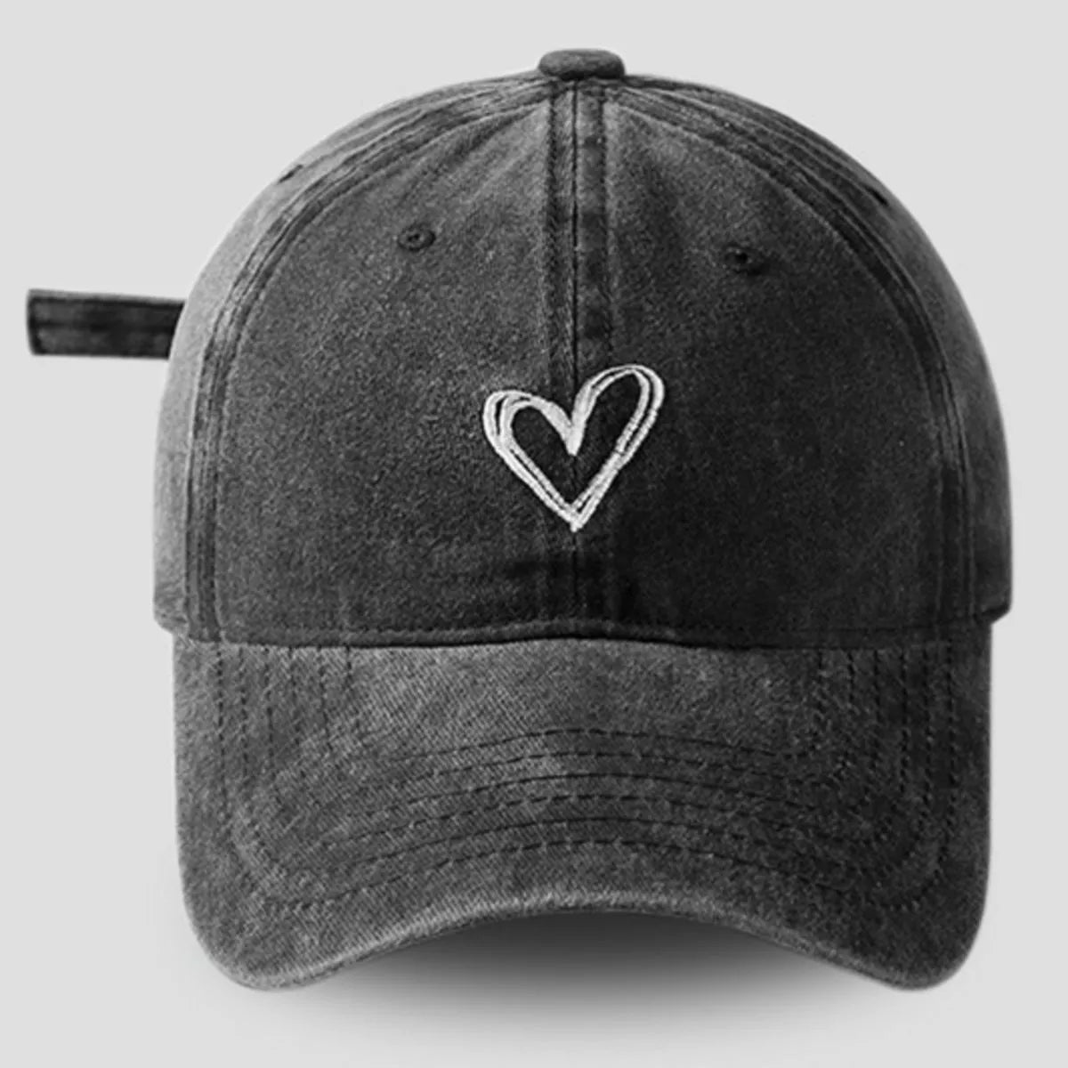 Vintage-washed cotton baseball cap with embroidered heart detail, curved brim, and adjustable back.