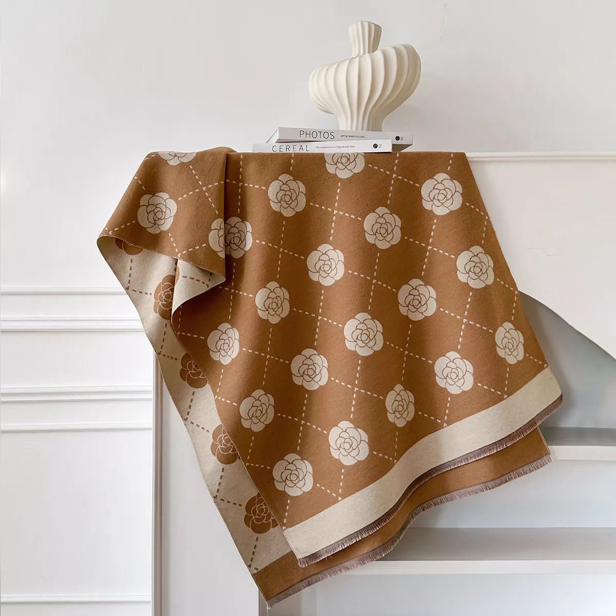 Floral wrap scarf with elegant geometric pattern draped over a neutral coat