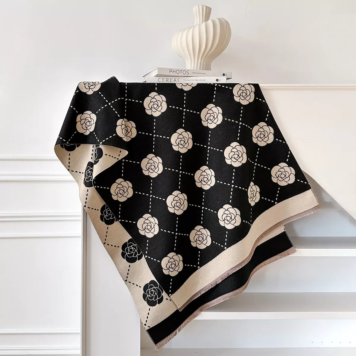 Floral wrap scarf with elegant geometric pattern draped over a neutral coat