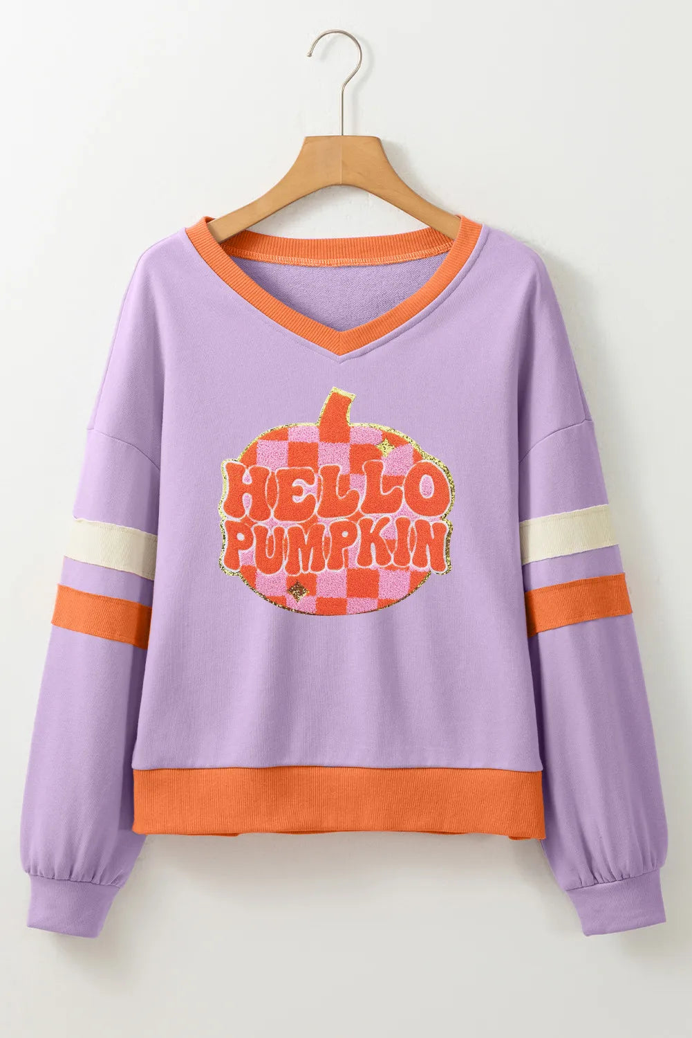 Woman wearing a lilac sweatshirt with a glittery orange checkered pumpkin and the phrase “Hello Pumpkin,” styled with denim shorts — cozy fall sweatshirt from A Whimsical Affair.