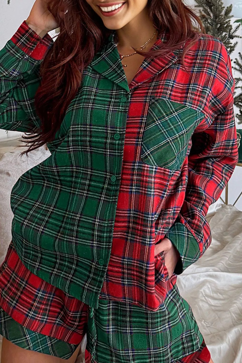 Model wearing green and red plaid button-down pajama set with red contrast pocket and shorts.