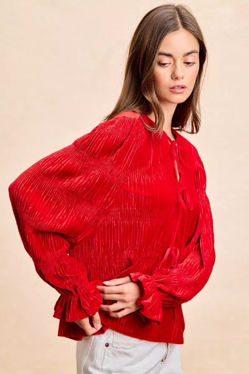 Red velvet long-sleeve blouse with tie-front bows and a neck drop design.