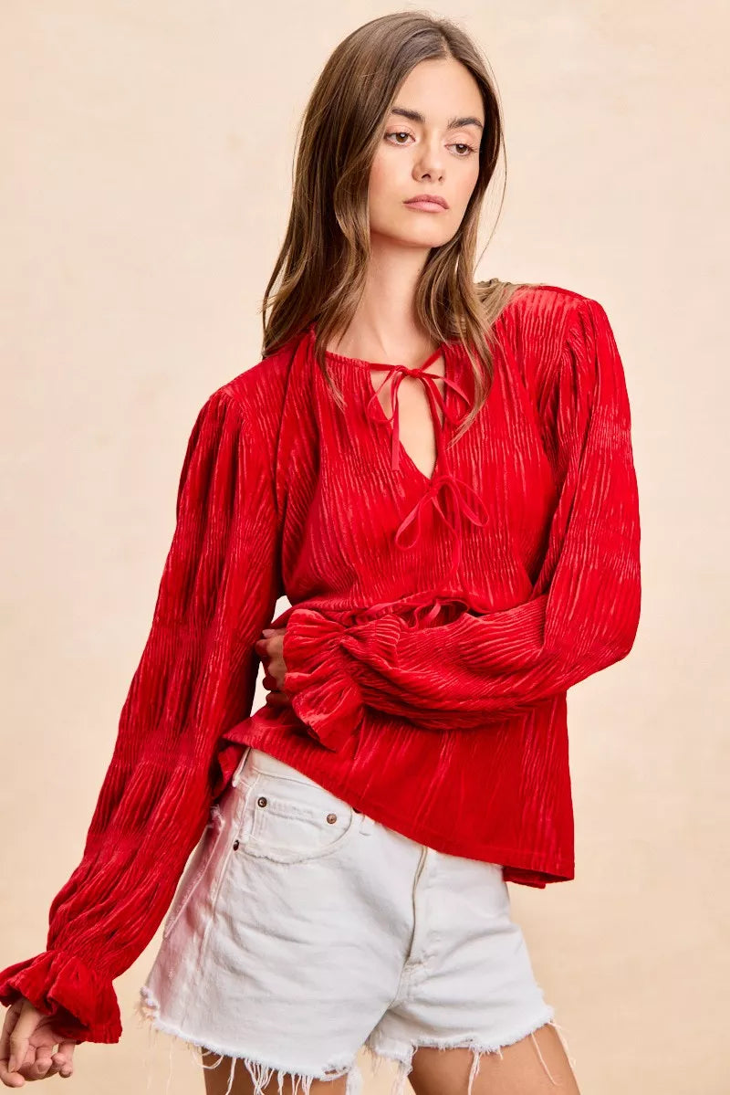 Red velvet long-sleeve blouse with tie-front bows and a neck drop design.