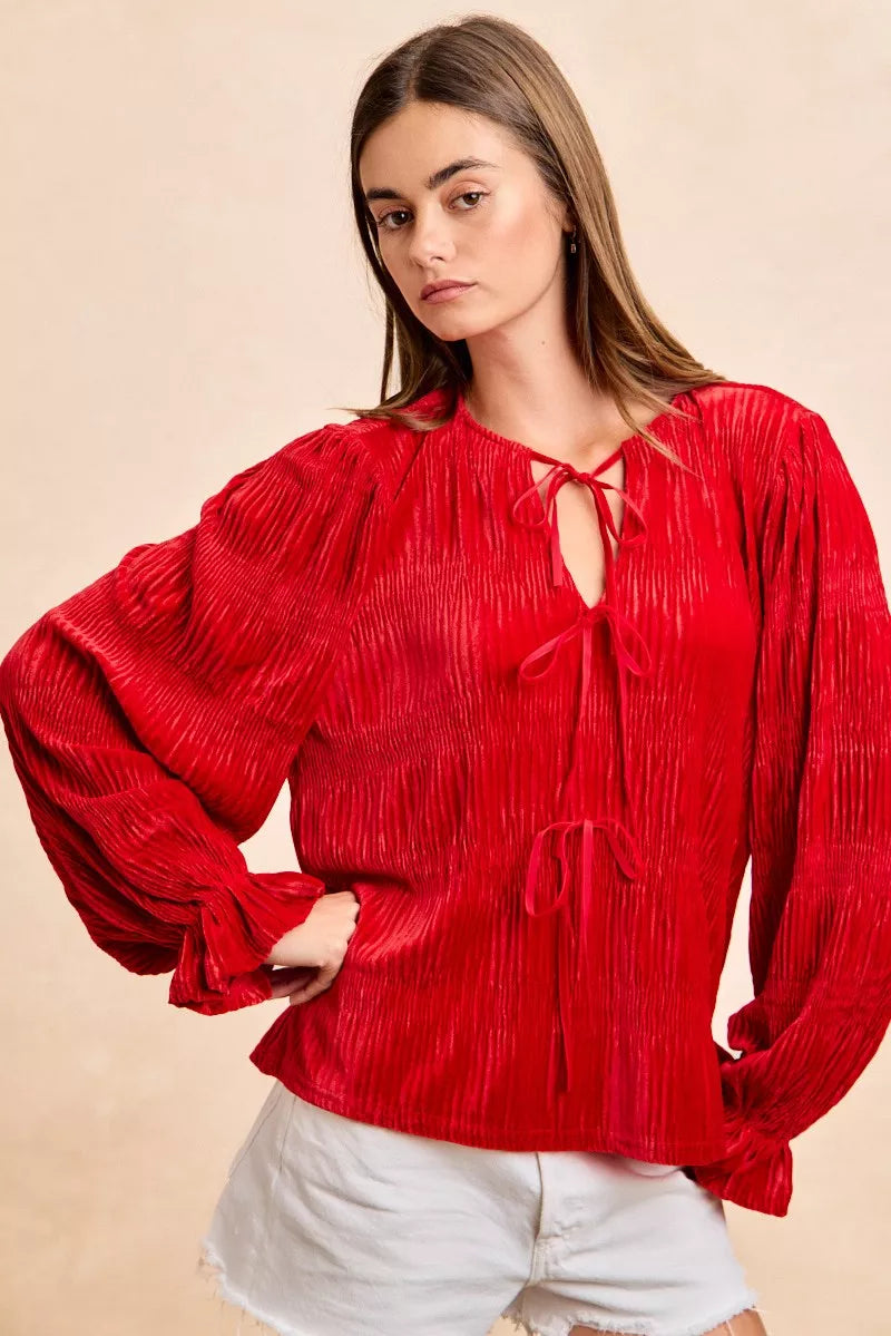Red velvet long-sleeve blouse with tie-front bows and a neck drop design.
