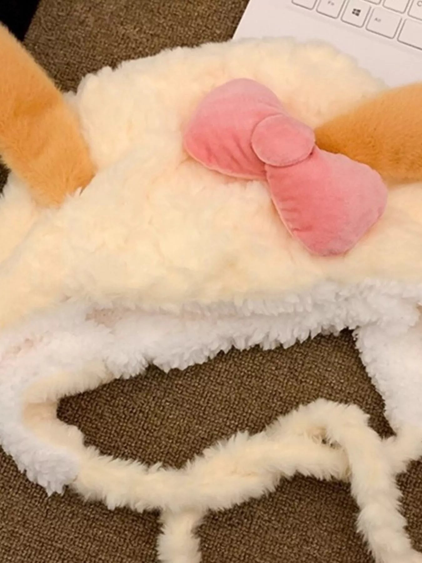 Soft plush earflap hood with floppy ears and pink velvet bow.