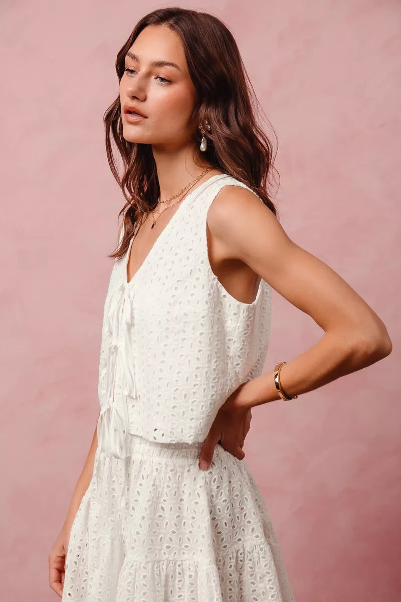 Ivory floral eyelet lace two-piece set with tie-front vest top and tiered mini skirt.