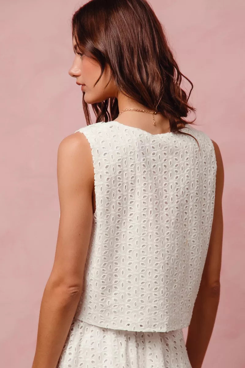 Ivory floral eyelet lace two-piece set with tie-front vest top and tiered mini skirt.