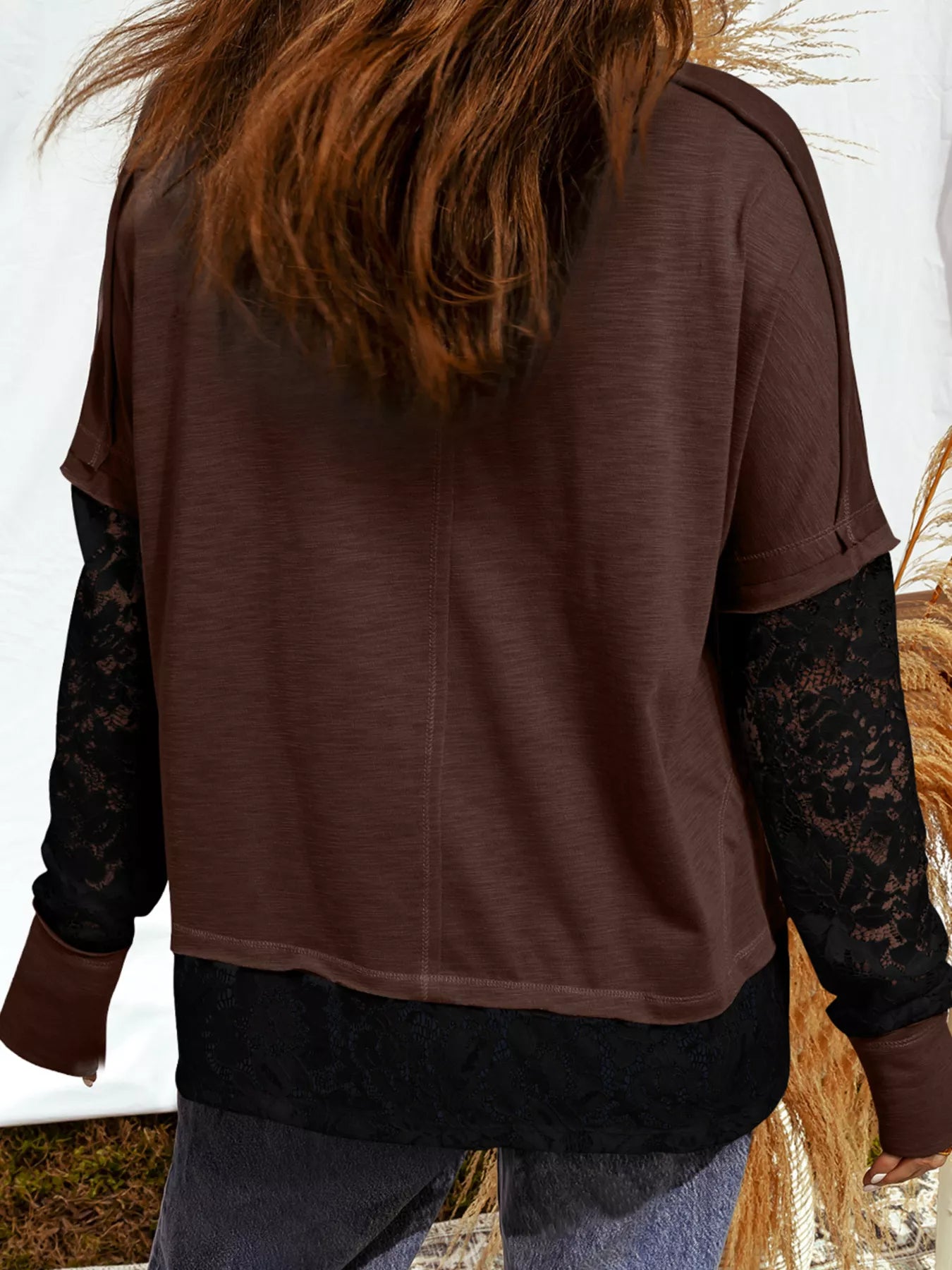 Woman wearing an oversized brown “Spooky” sequin graphic top with black lace sleeves and hem — layered Halloween tee from A Whimsical Affair.