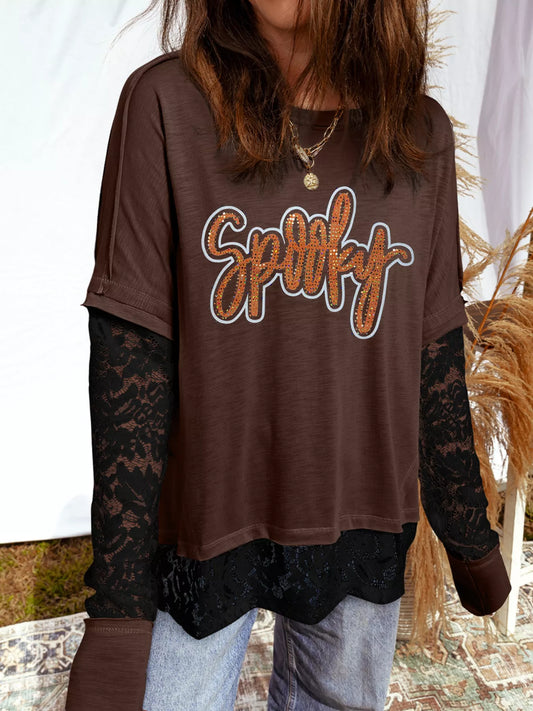 Woman wearing an oversized brown “Spooky” sequin graphic top with black lace sleeves and hem — layered Halloween tee from A Whimsical Affair.