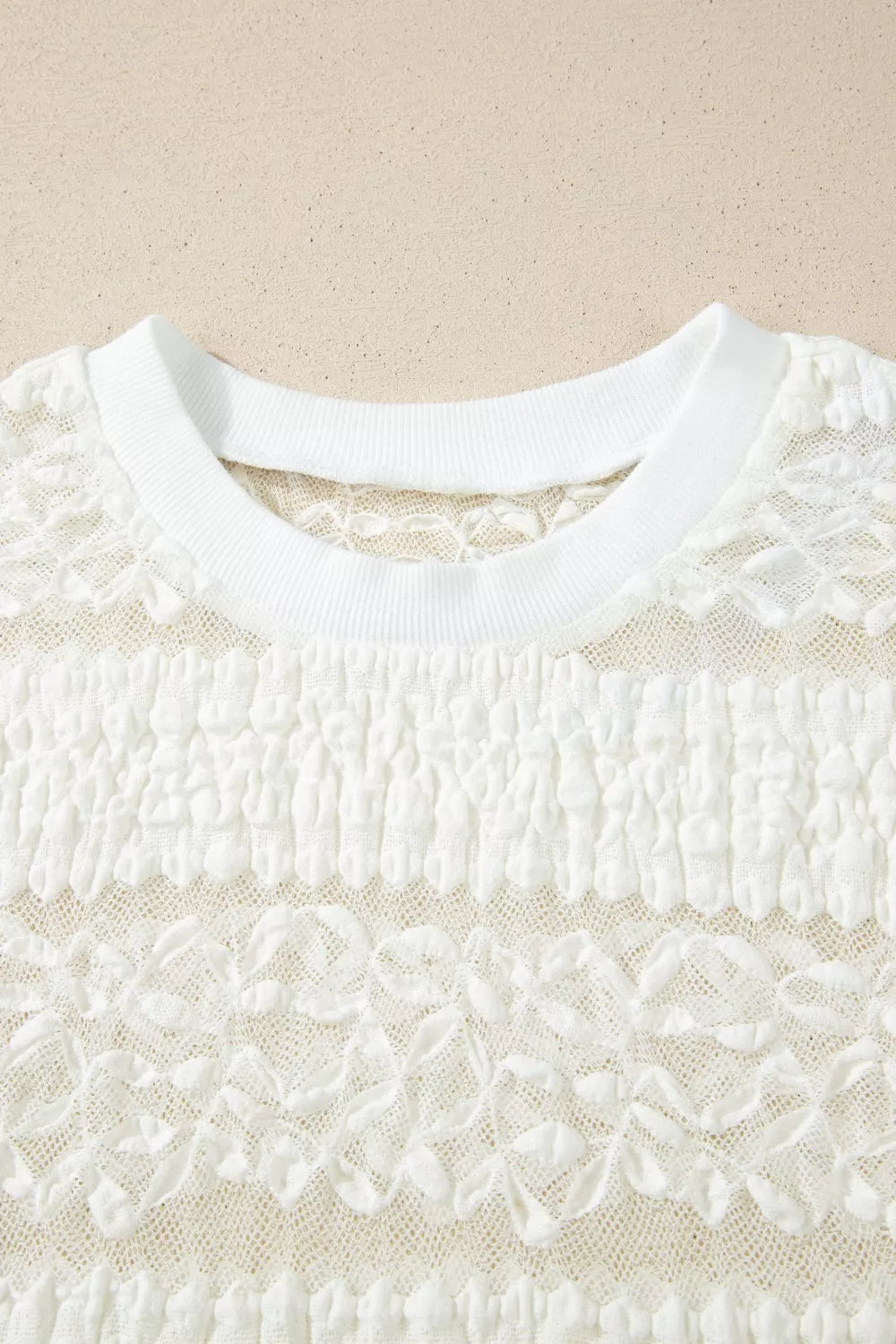 White sheer lace short sleeve tee with floral pattern, slightly stretchy fit, and delicate feminine texture styled with dark denim jeans.