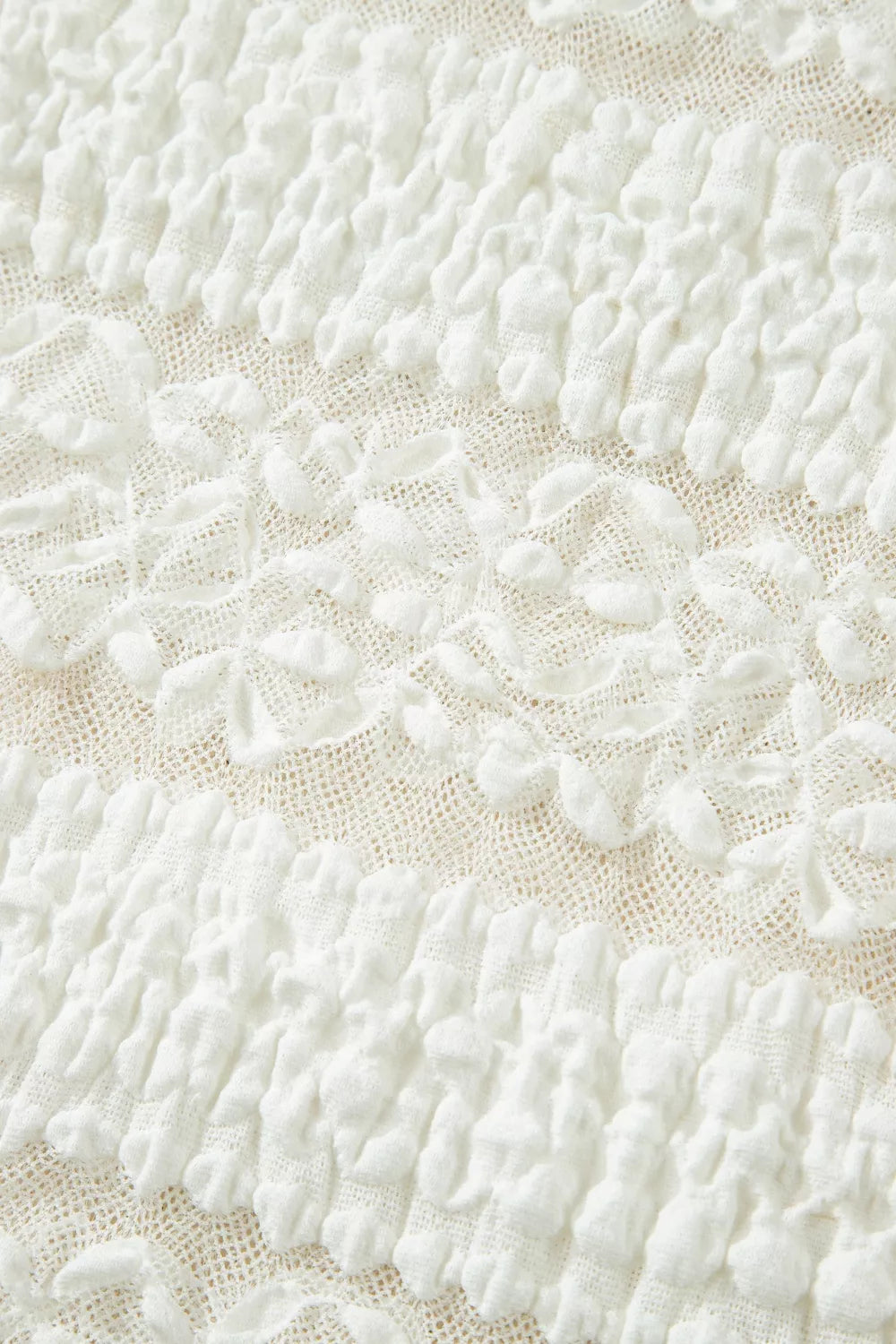 White sheer lace short sleeve tee with floral pattern, slightly stretchy fit, and delicate feminine texture styled with dark denim jeans.