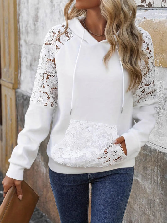 Model wearing a white hoodie with lace detailing on the sleeves and pocket, featuring a drawstring hood and relaxed fit, styled with denim jeans for a casual feminine look.