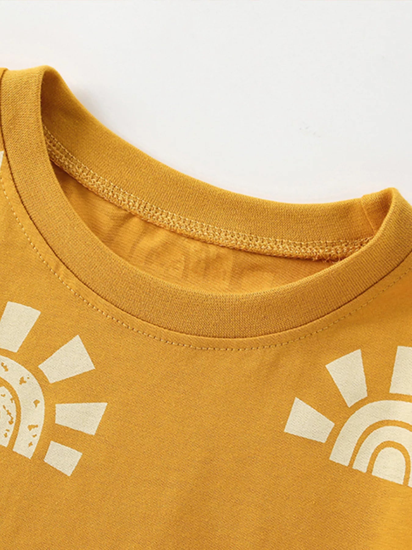Mustard yellow kids two piece set with white sunshine print short sleeve top and matching shorts