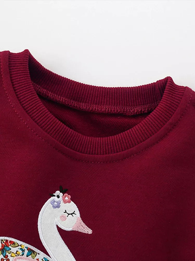 Girls long-sleeve sweatshirt with swan graphic and ruffled tulle hem.