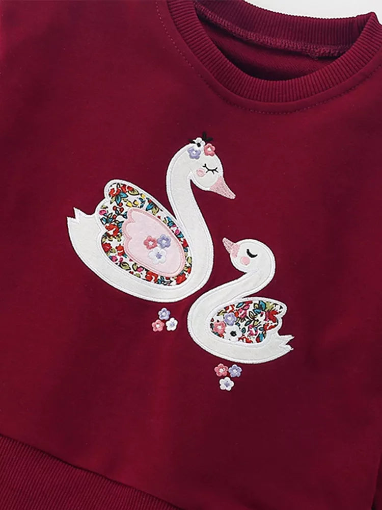 Girls long-sleeve sweatshirt with swan graphic and ruffled tulle hem.