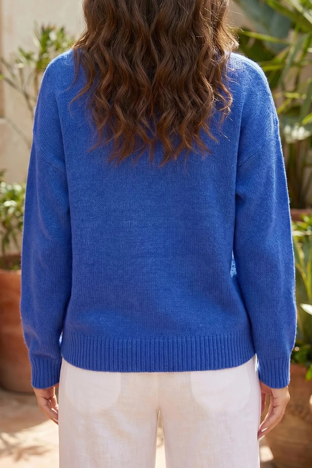 Blue knit sweater with duck graphic, relaxed off-shoulder neckline, ribbed trim, and soft slightly stretchy recycled-blend fabric.