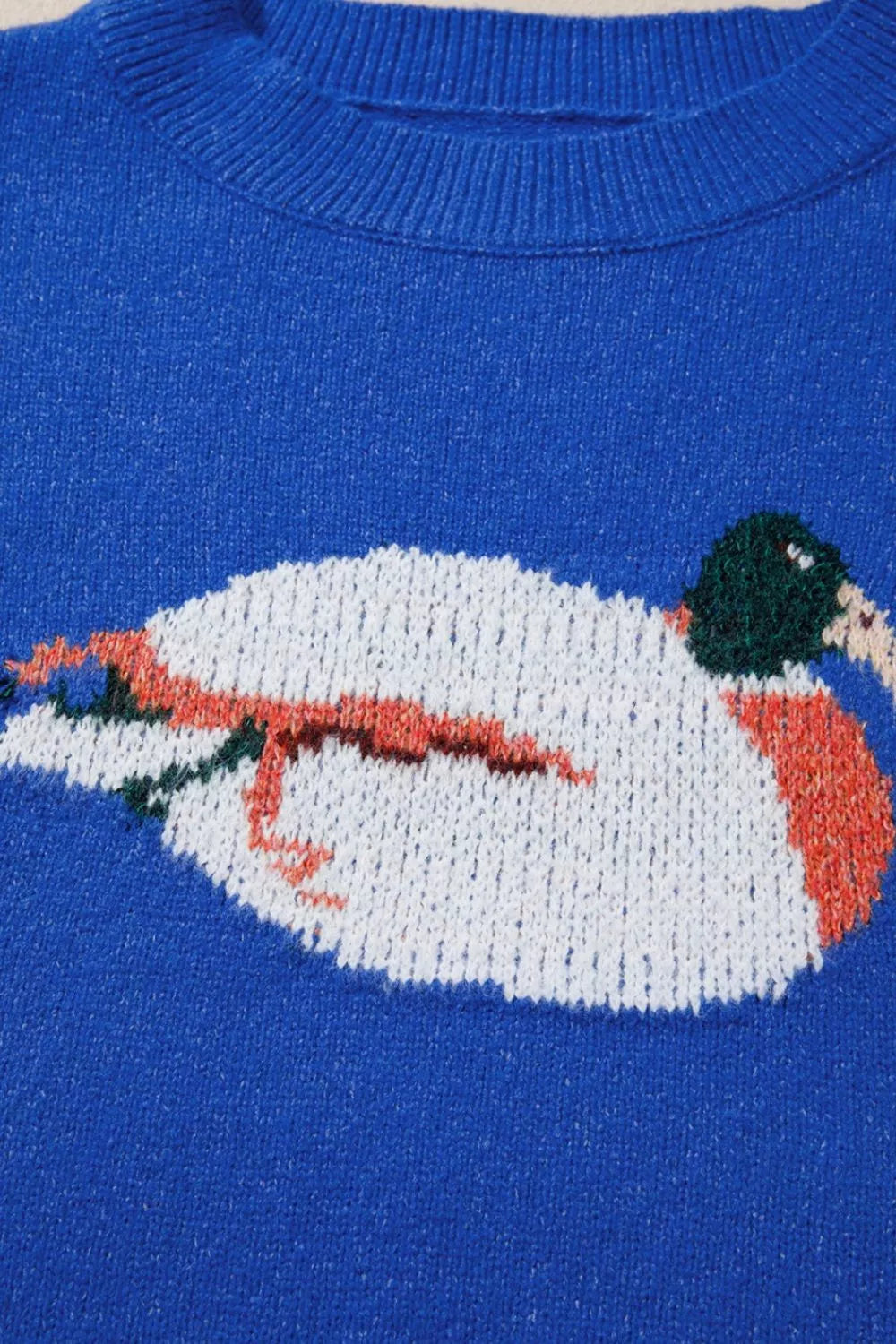 Blue knit sweater with duck graphic, relaxed off-shoulder neckline, ribbed trim, and soft slightly stretchy recycled-blend fabric.