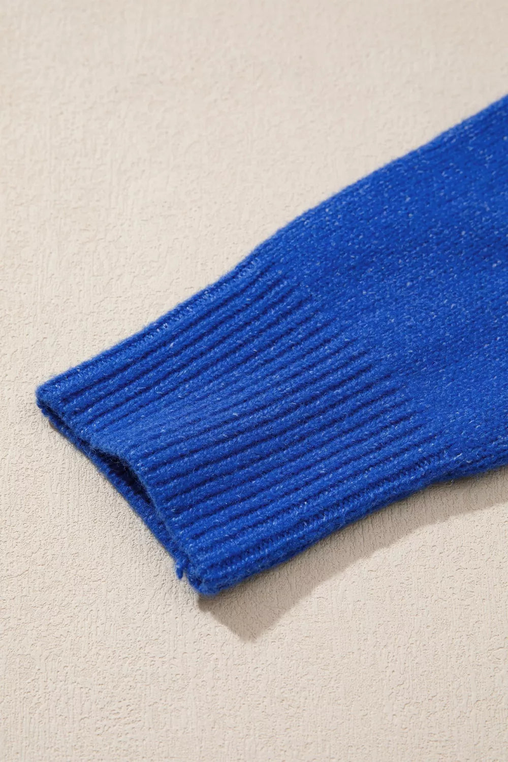 Blue knit sweater with duck graphic, relaxed off-shoulder neckline, ribbed trim, and soft slightly stretchy recycled-blend fabric.