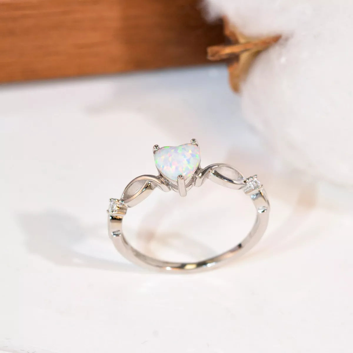 Heart-shaped opal ring with twist band and zircon accents in sterling silver.