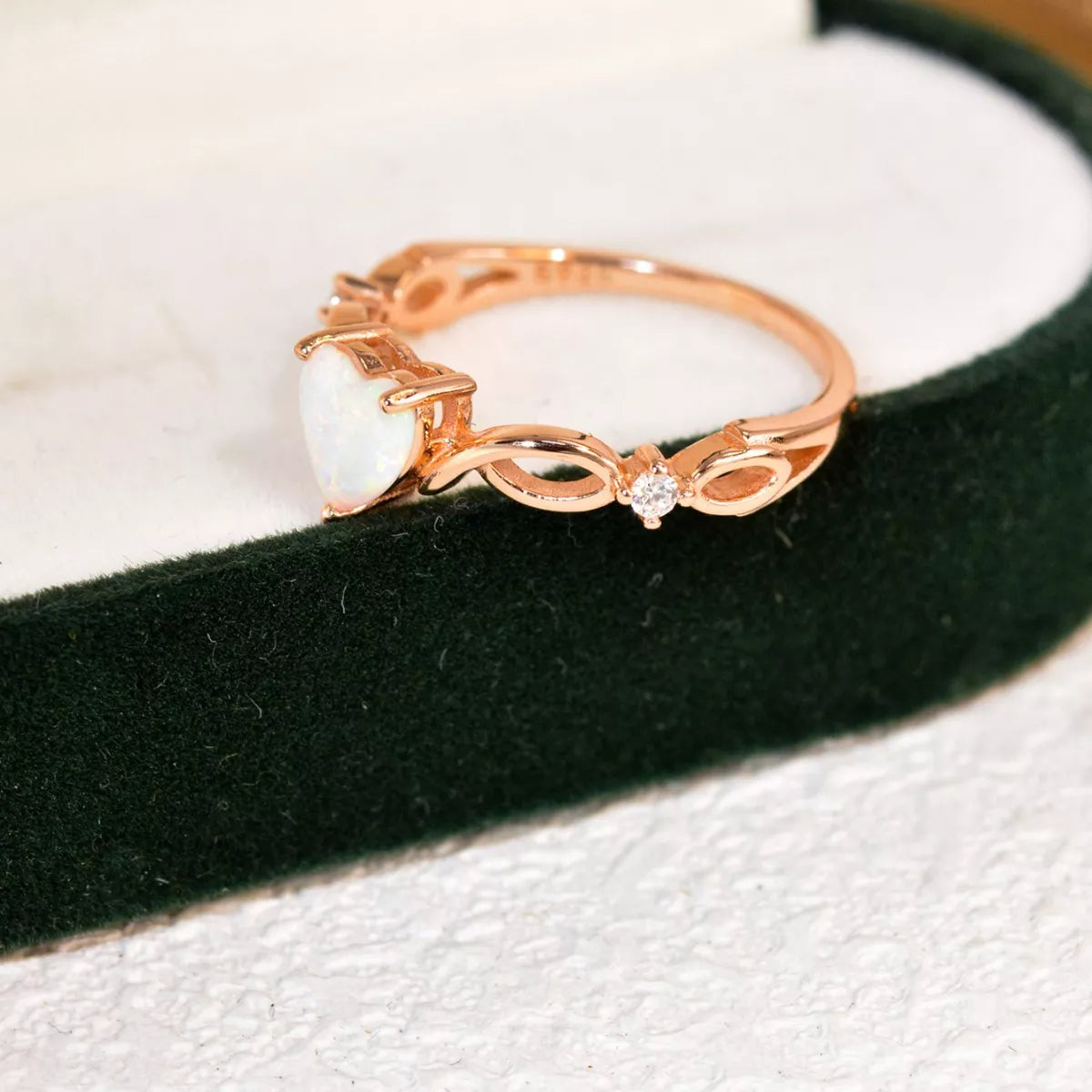 Heart-shaped opal ring with twist band and zircon accents in sterling silver.