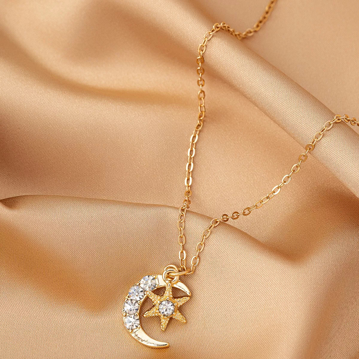 Gold layered necklace featuring star and crescent moon pendants, celestial 18K gold-plated jewelry