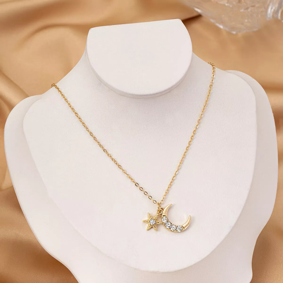 Gold layered necklace featuring star and crescent moon pendants, celestial 18K gold-plated jewelry
