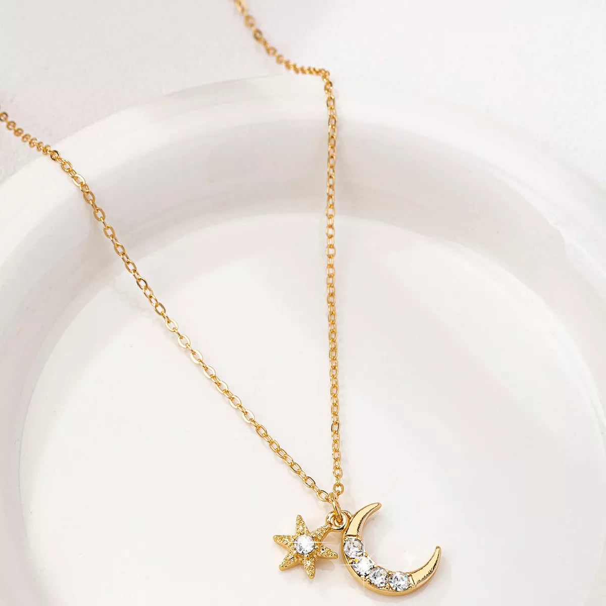Gold layered necklace featuring star and crescent moon pendants, celestial 18K gold-plated jewelry
