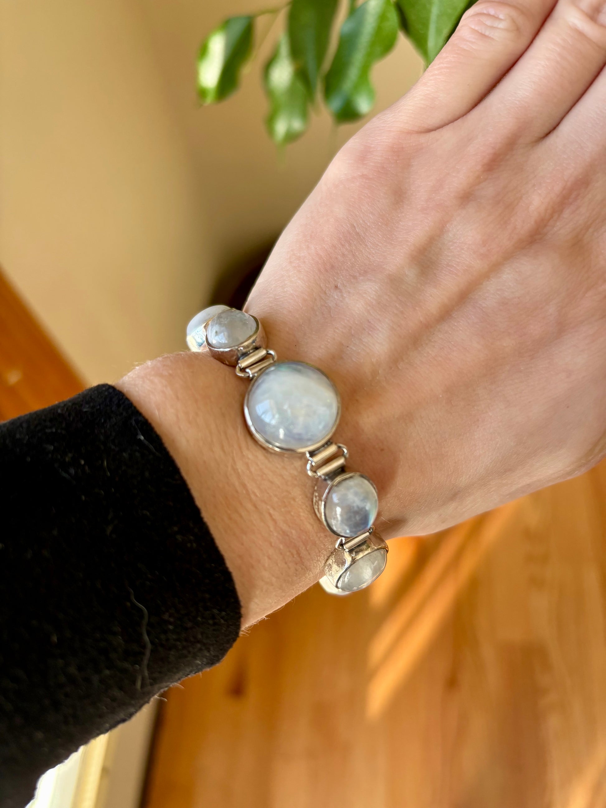 Sterling silver moonstone bracelet with multiple round moonstones and a toggle clasp, shown on wrist and display hand