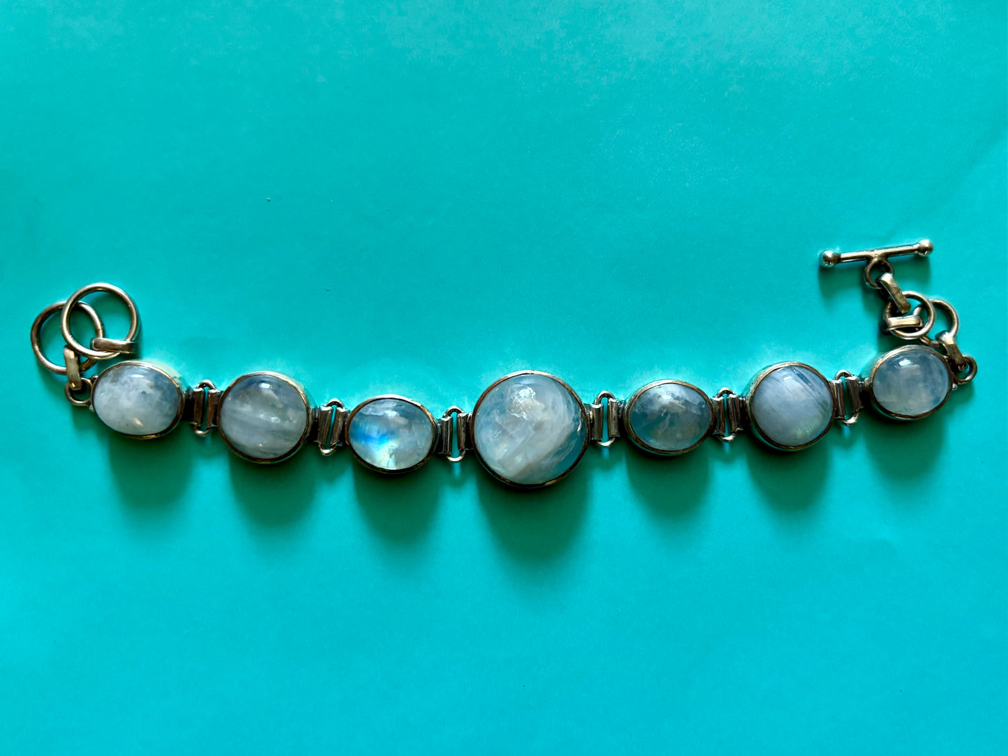 Sterling silver moonstone bracelet with multiple round moonstones and a toggle clasp, shown on wrist and display hand
