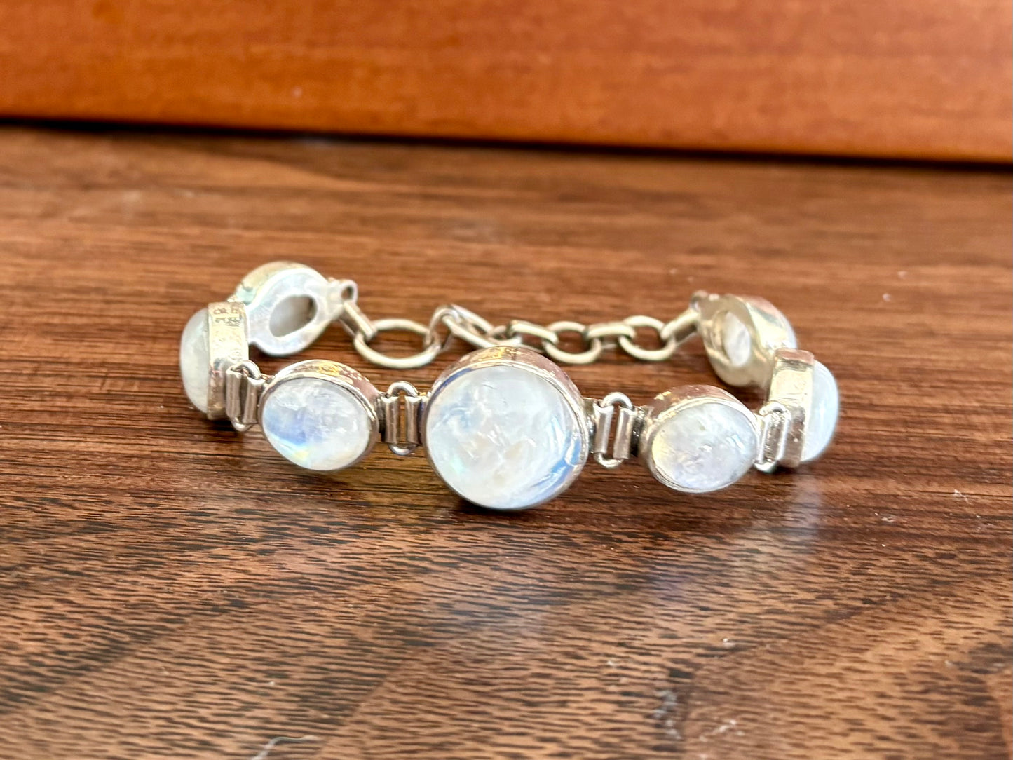 Sterling silver moonstone bracelet with multiple round moonstones and a toggle clasp, shown on wrist and display hand