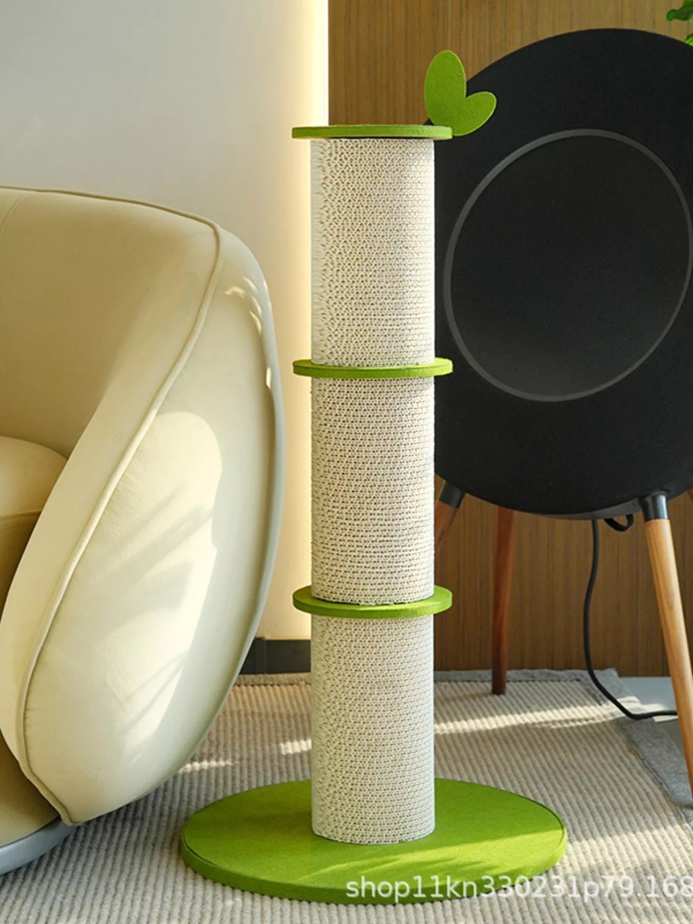 White cat stretching on modern green linen scratching tower with leaf accent