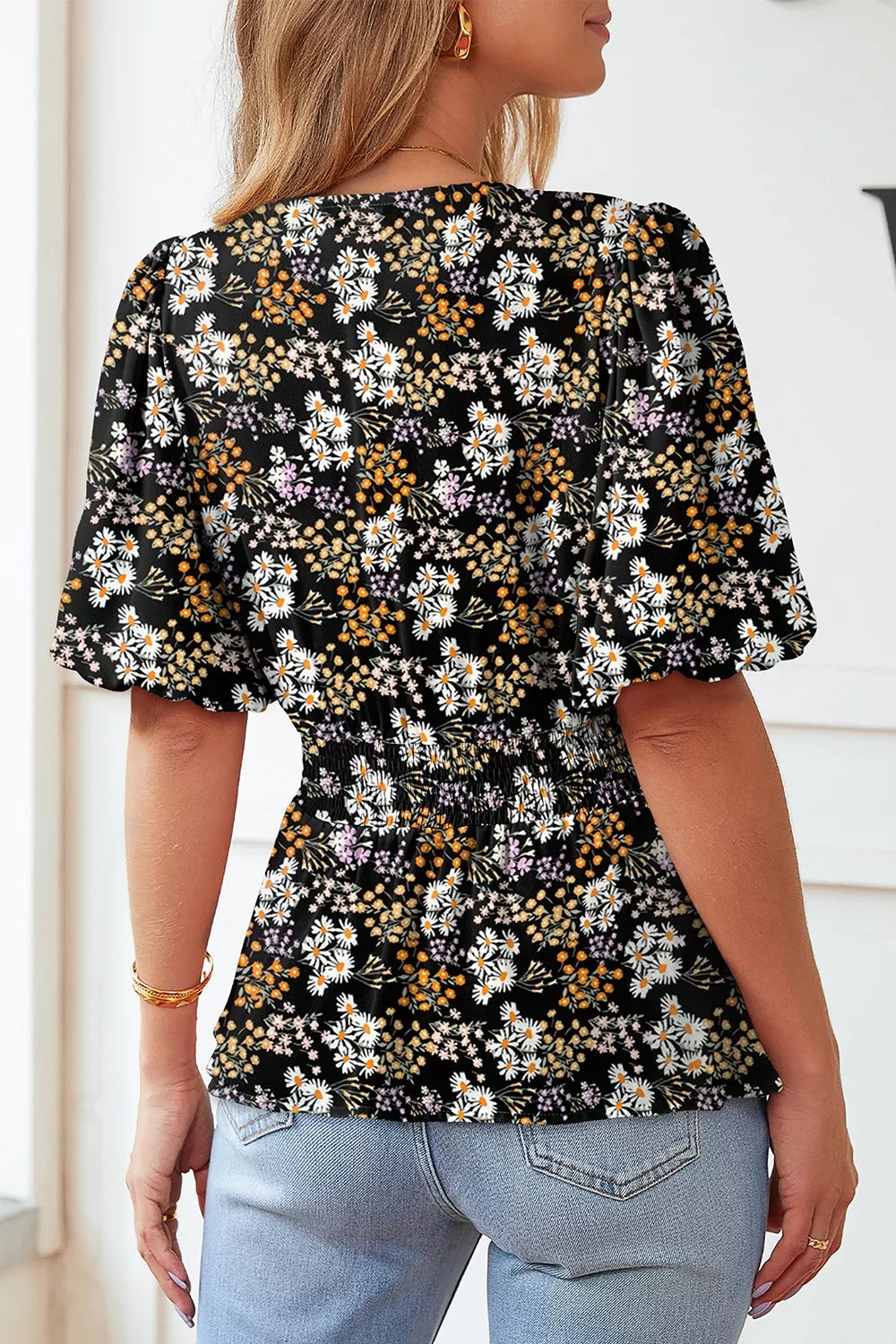 Black floral peplum blouse with smocked waist and short sleeves