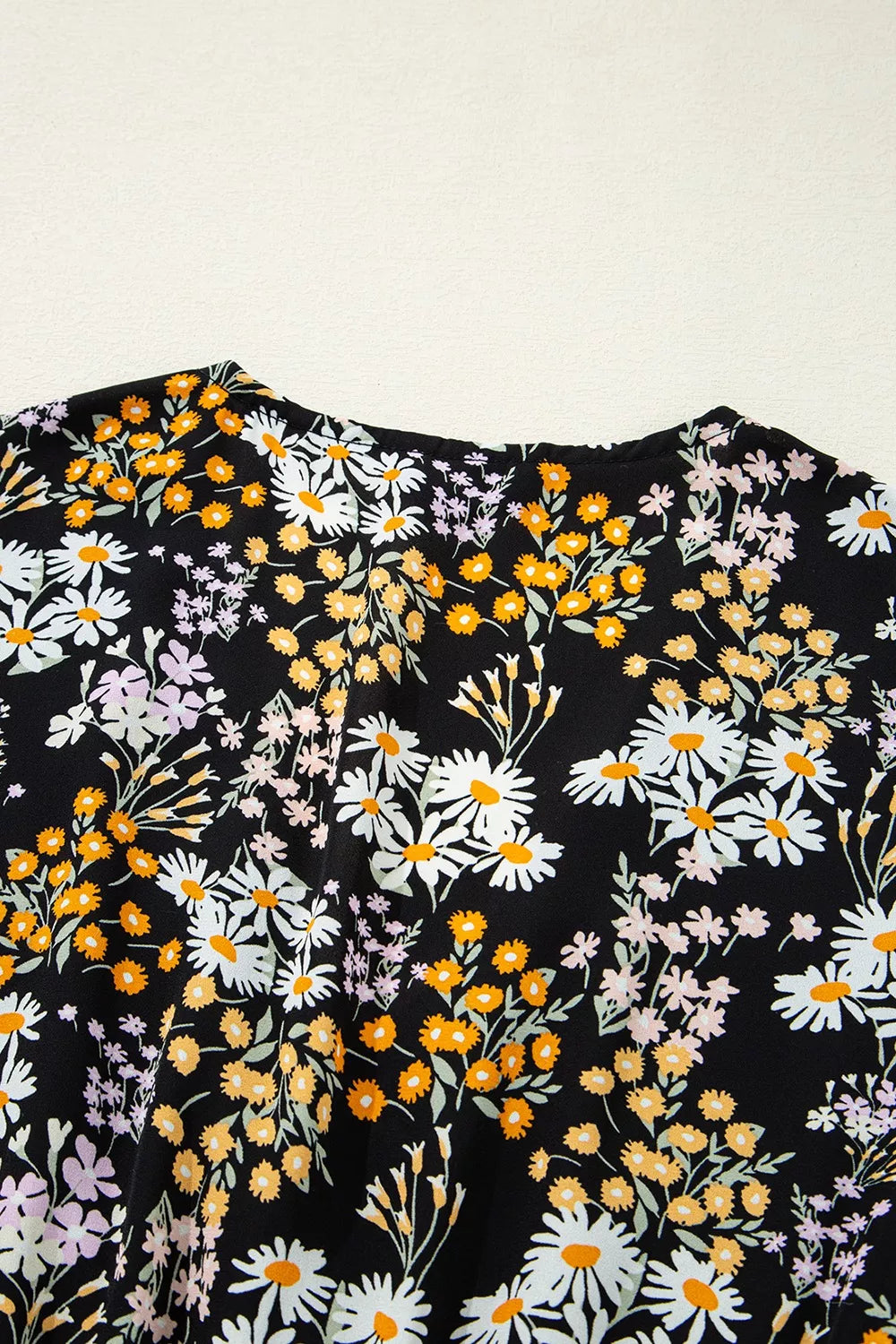 Black floral peplum blouse with smocked waist and short sleeves
