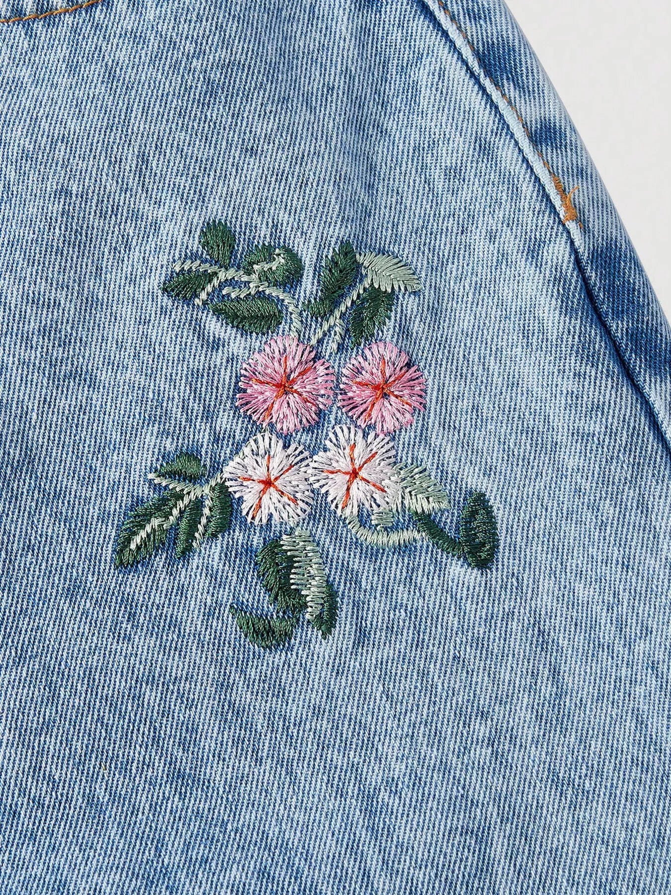 Wide leg jeans with delicate floral embroidery, pocketed design, no-stretch cotton-blend denim, and soft boho garden-inspired style.