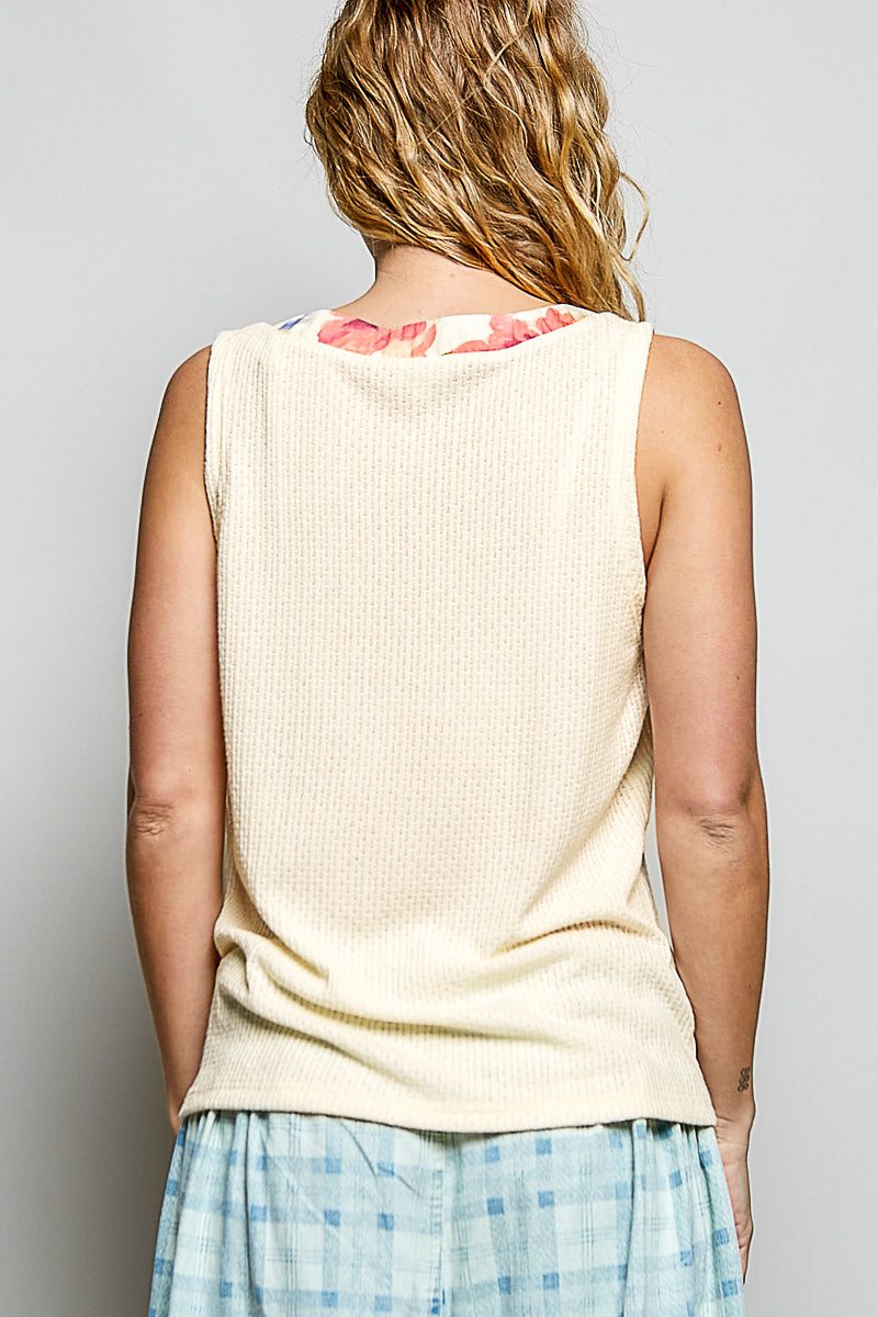 Cream sleeveless textured knit top with floral trim and button front