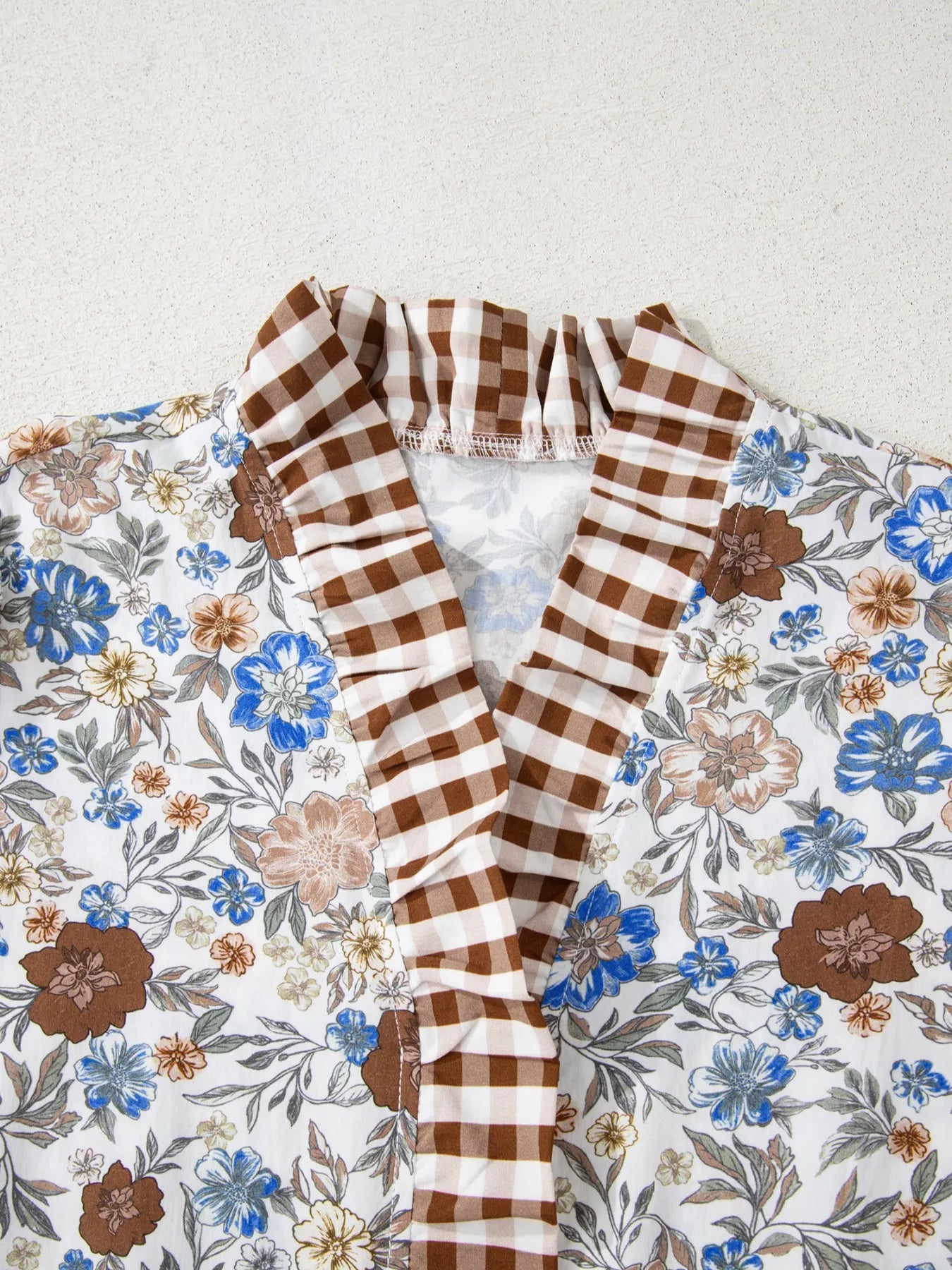 Floral blouse with gingham ruffle V-neckline and frilled sleeves styled with blue jeans